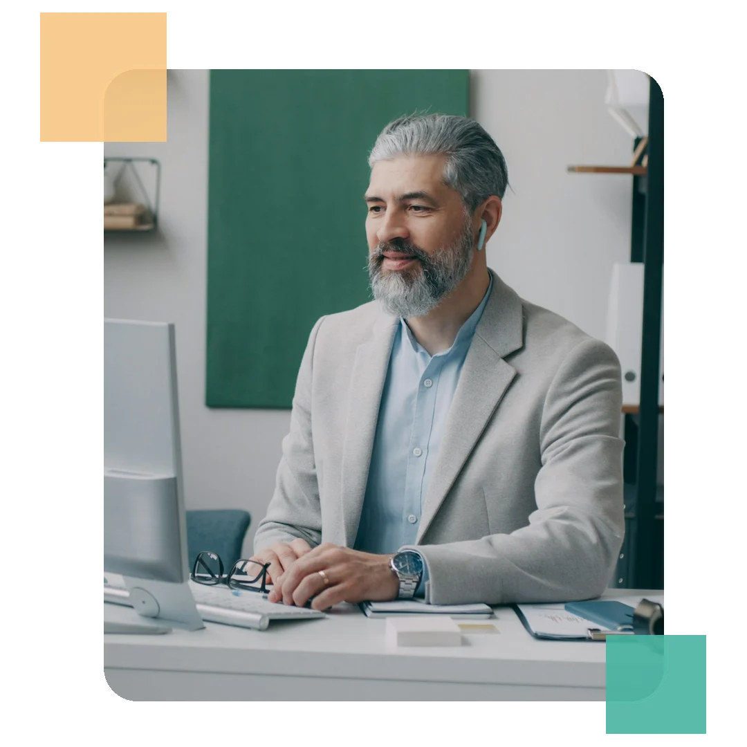 Gestor sorrindo em sua mesa de trabalho em escritório corporativo